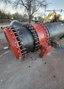 A large pipe lying on the ground next to construction equipment.