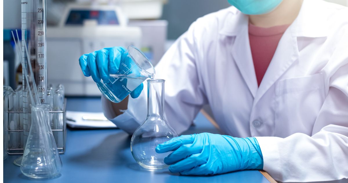 A scientist testing water quality in a lab with a beaker and test tube.